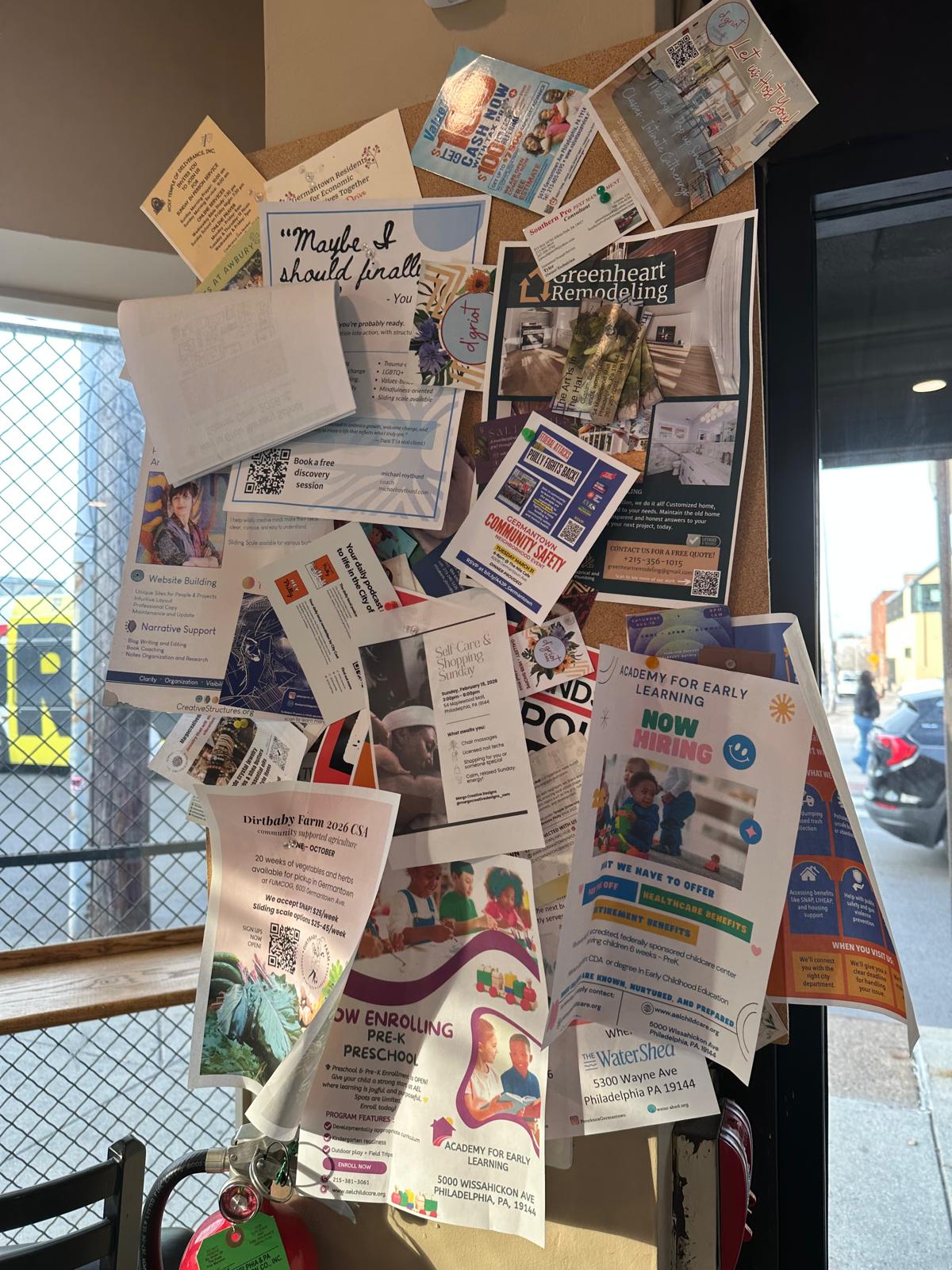 Cluttered paper noticeboard inside a local business, example 1